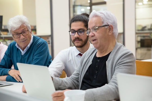 Three people looking at a screen on a laptop