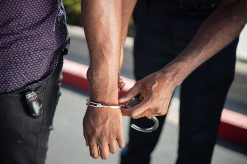 person in handcuffs being arrested