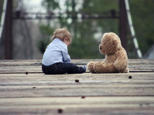 Photo of toddler sat with teddy bear
