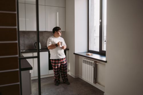 Young man alone looking out of a window